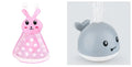 Automatic water spray whale bath toy with lights on a blue base.