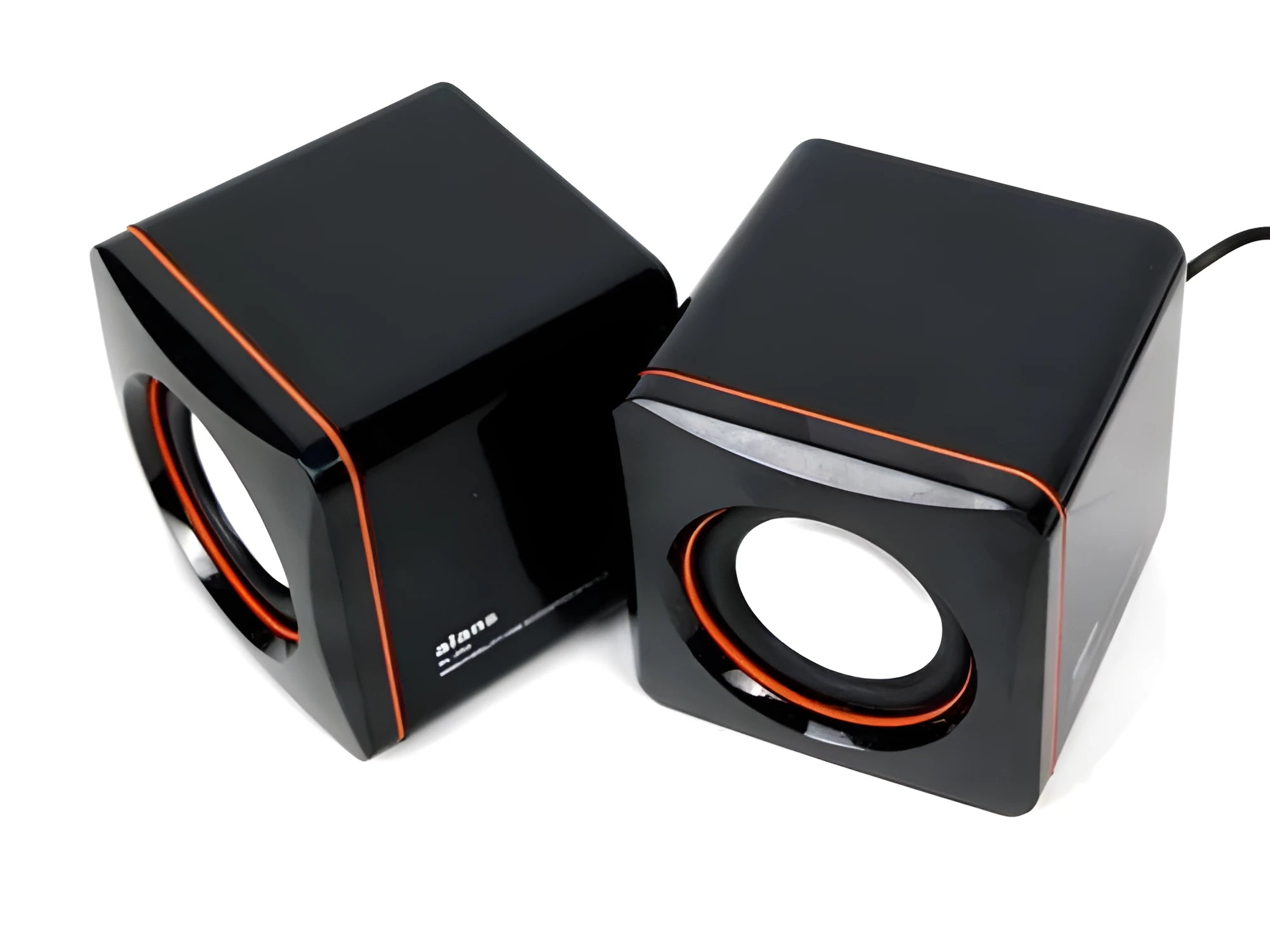 Black small square USB-powered computer speaker on desktop next to monitor