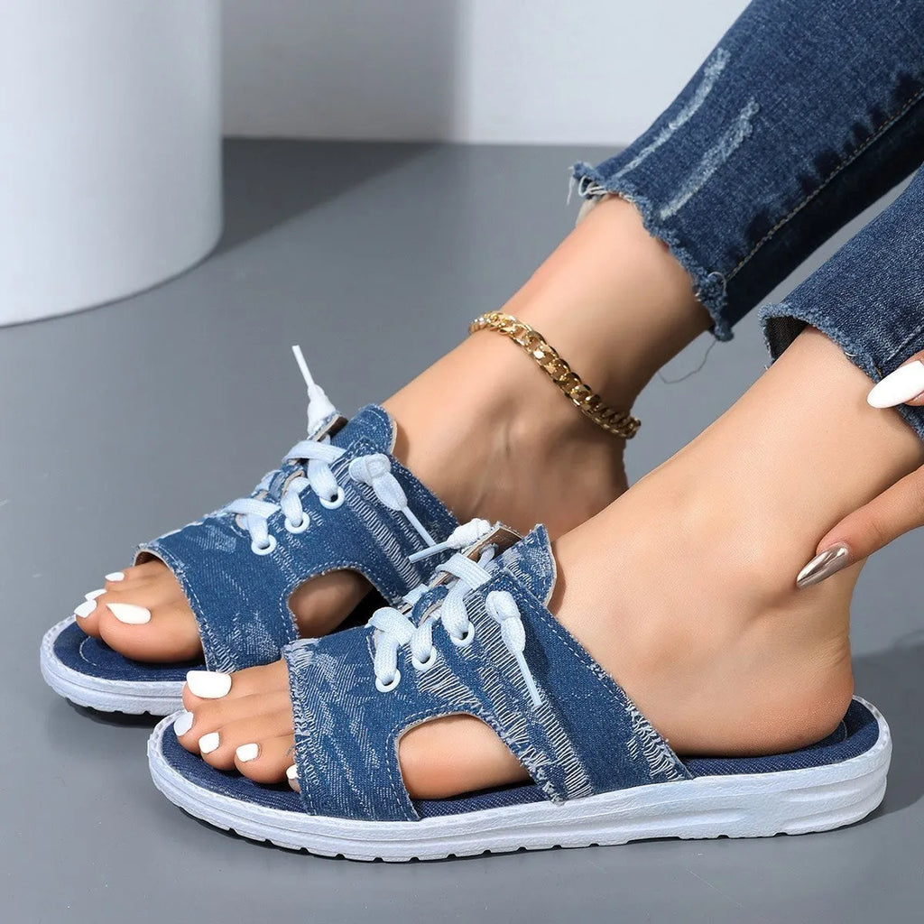 Blue women's flat canvas slippers with a cloth upper and rubber sole.