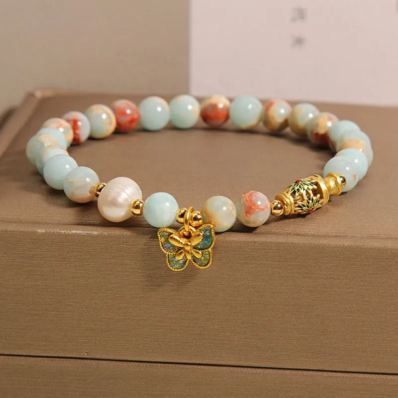 Blue women's bracelet with butterfly pendant containing Shoushan stone and freshwater pearls.
