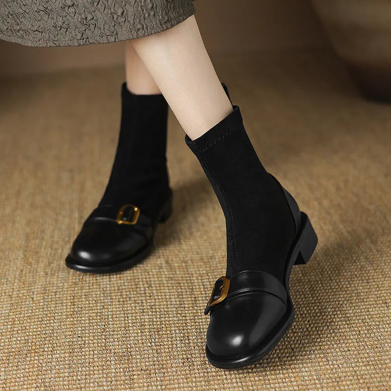 Women's black low heel Martin boot with lace-up front and decorative buckle stitching on a round toe.