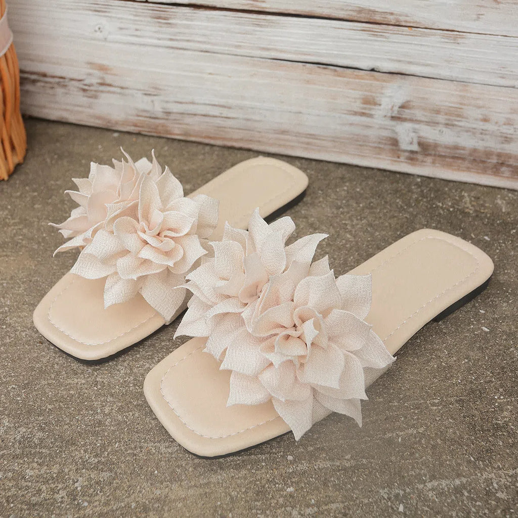 Women's flat flip-flops with flower detail on PU upper, available in apricot, black, white, red, and green