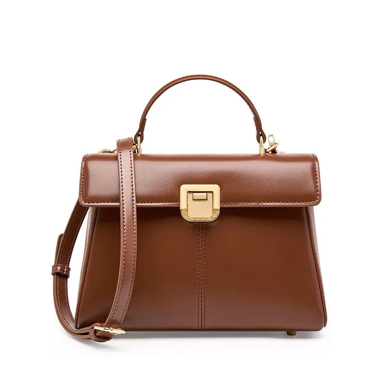 Women's black genuine leather shoulder bag with vachette clasp closure showing internal compartments