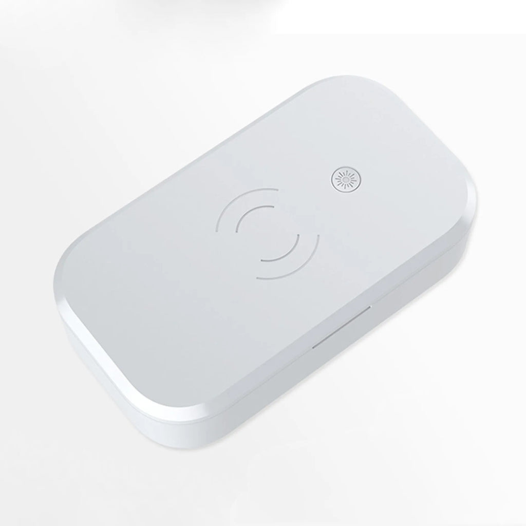 White UV disinfection box for nail tools with wireless phone charging function on a table.