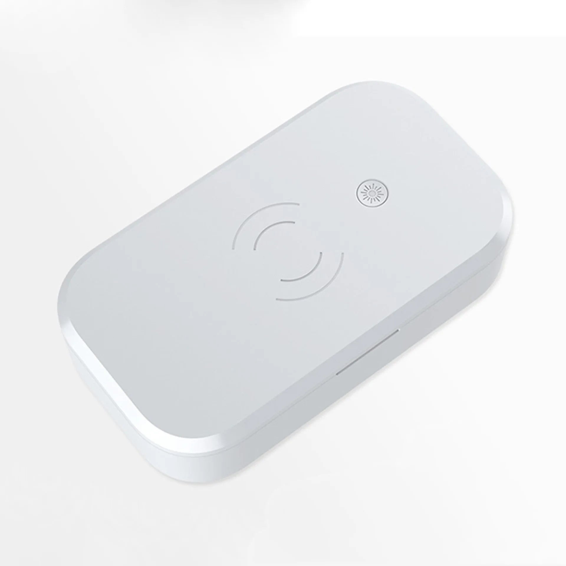 White UV disinfection box for nail tools with wireless phone charging function on a table.