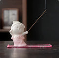 Cute ceramic female court attendant figurine incense burner decoration on a desk.