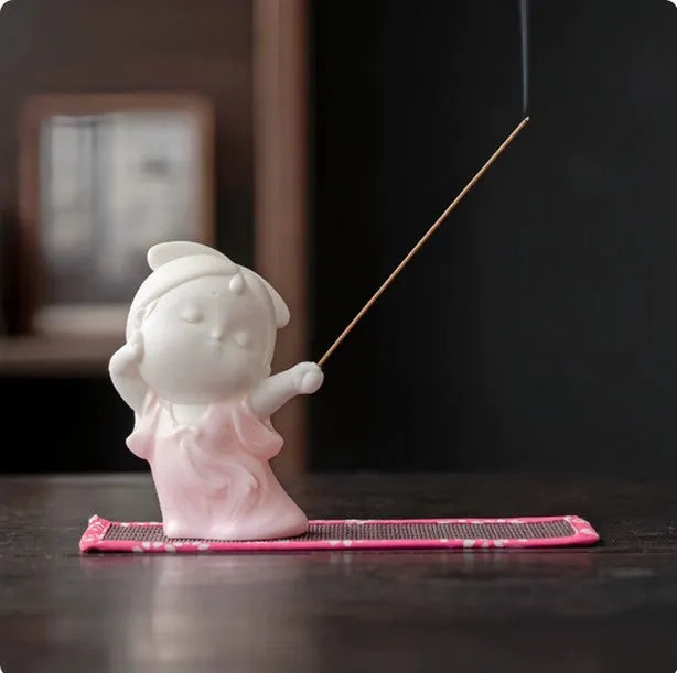 Cute ceramic female court attendant figurine incense burner decoration on a desk.