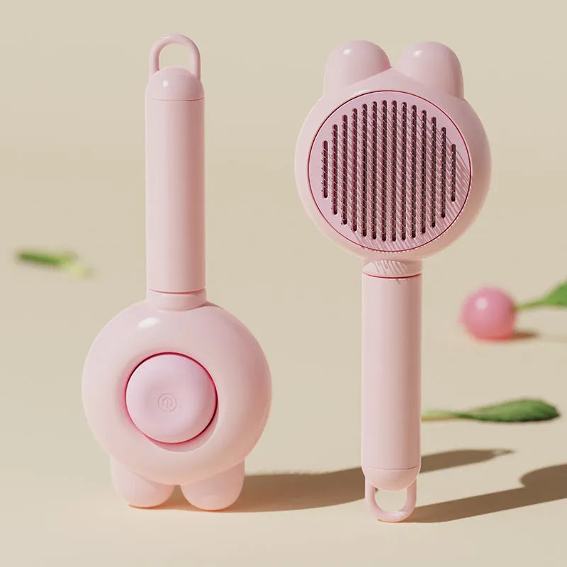 Self-cleaning pet brush with coloured comfort-grip handle and metal comb, shown with release button activated.