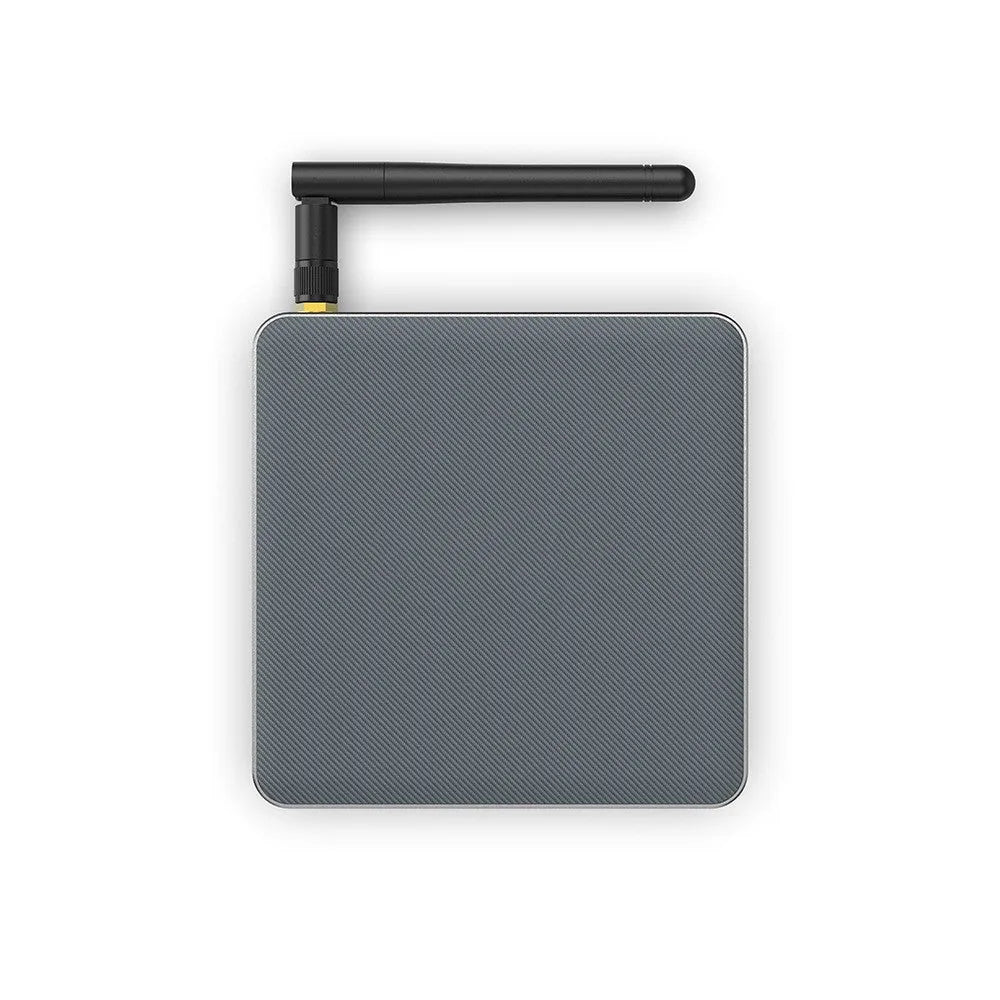 Black Android 8K network set-top box with remote, HDMI cable, and power supply on a wooden surface.