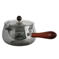 Transparent borosilicate glass teapot with wooden handle and infuser on rotary base