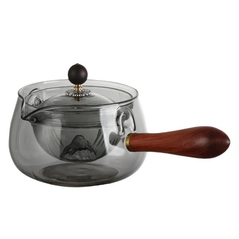 Transparent borosilicate glass teapot with wooden handle and infuser on rotary base