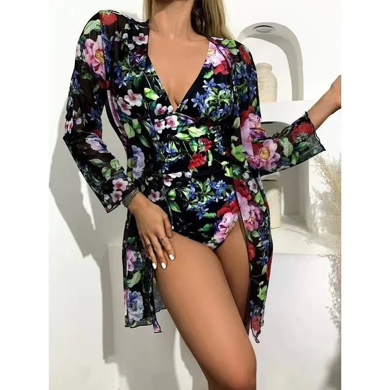 Women's floral print bikini and matching coat three-piece swimsuit set on a hanger.