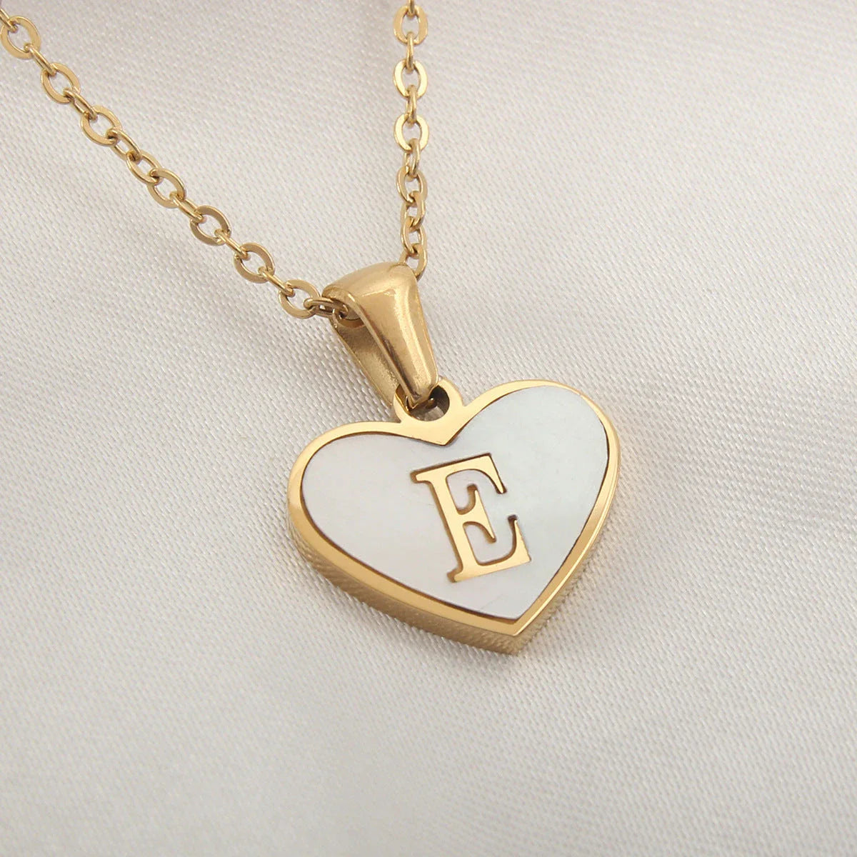 A personalized heart-shaped necklace with a 26-letter charm, crafted from high-quality stainless steel and gold plating.