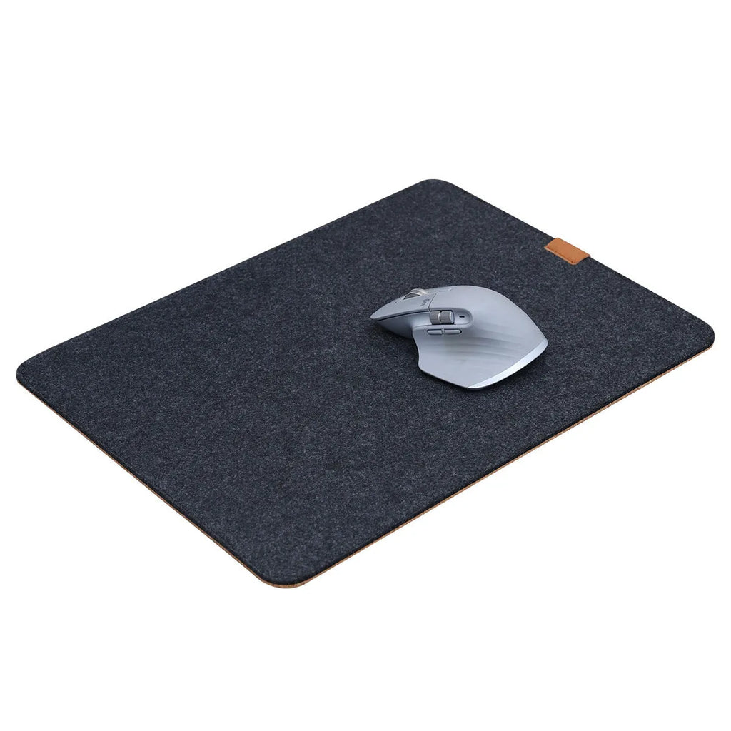 A grey and black felt cork desk mat with a mouse on it, shown on a wooden desk.