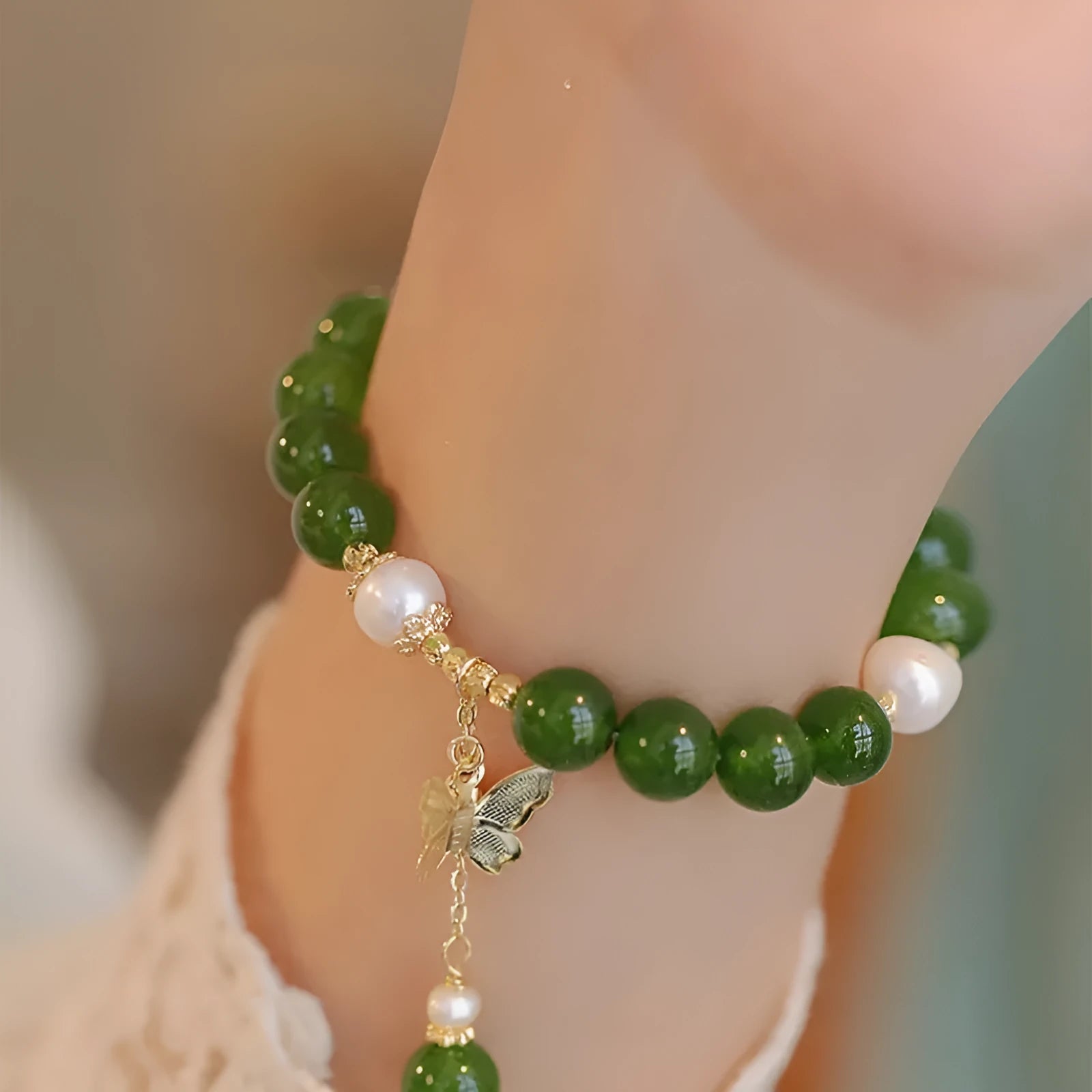 Close-up of a round natural green chalcedony bracelet on a woman's wrist.