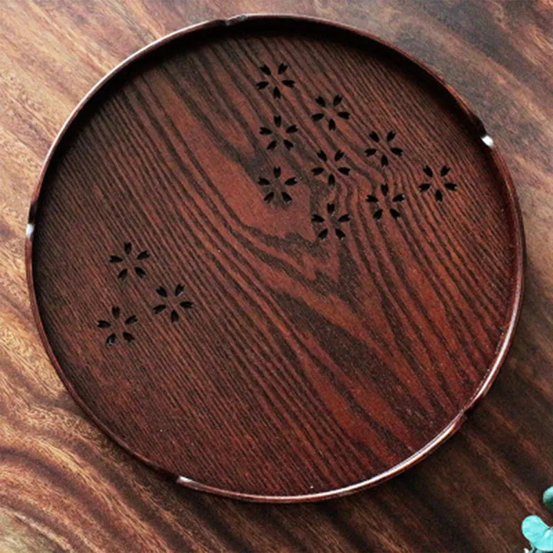 12 wooden circular plates with sakura flower cut-out designs arranged with storage tray