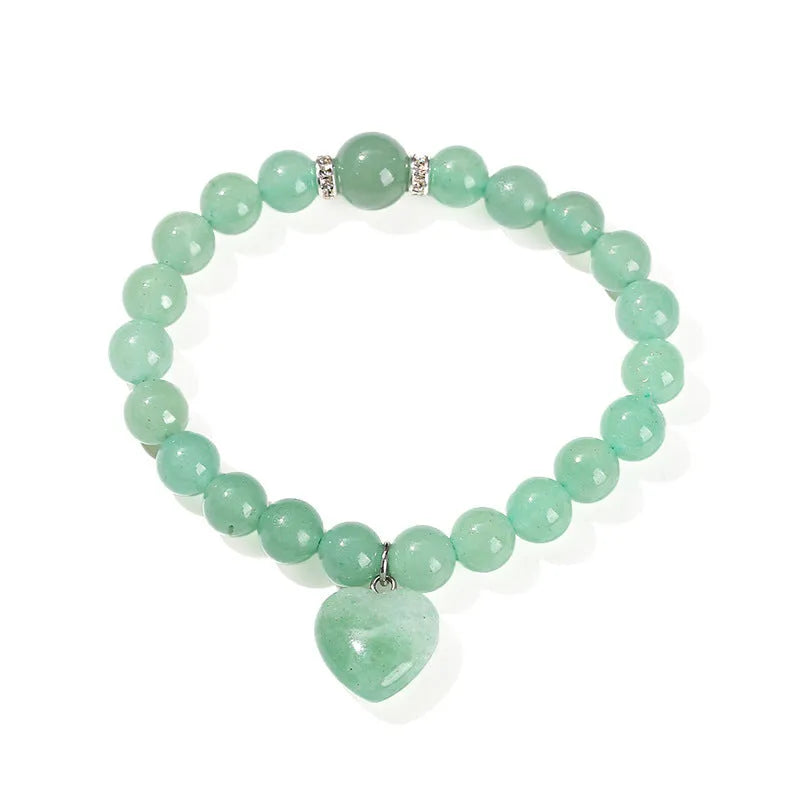 Natural stone love heart pendant bracelet on wrist, showing Tigereye, crystal or aventurine beads.