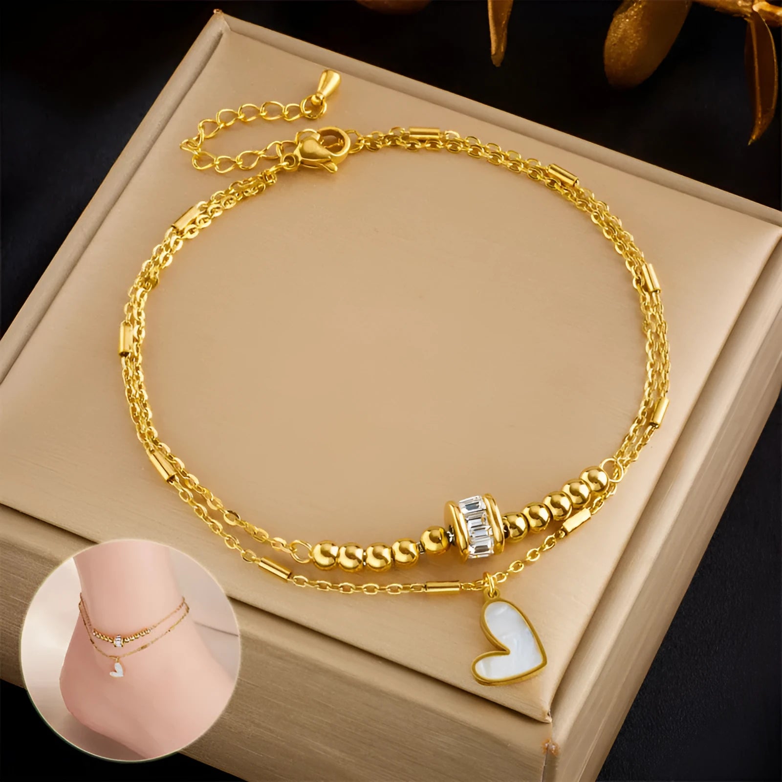 Gold titanium steel double-layer ankle chain with love heart charm and tassel on a white background