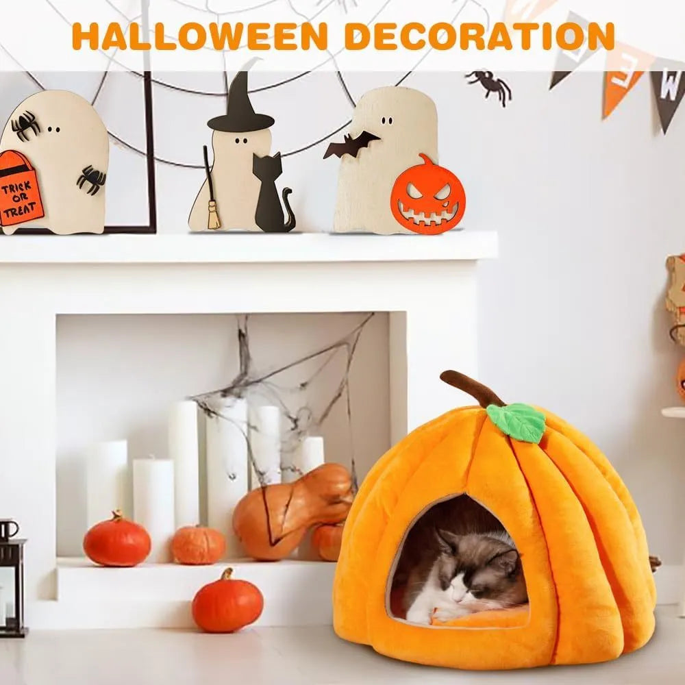 Pumpkin-shaped plush cat cave bed with a round entry hole on a wooden floor.