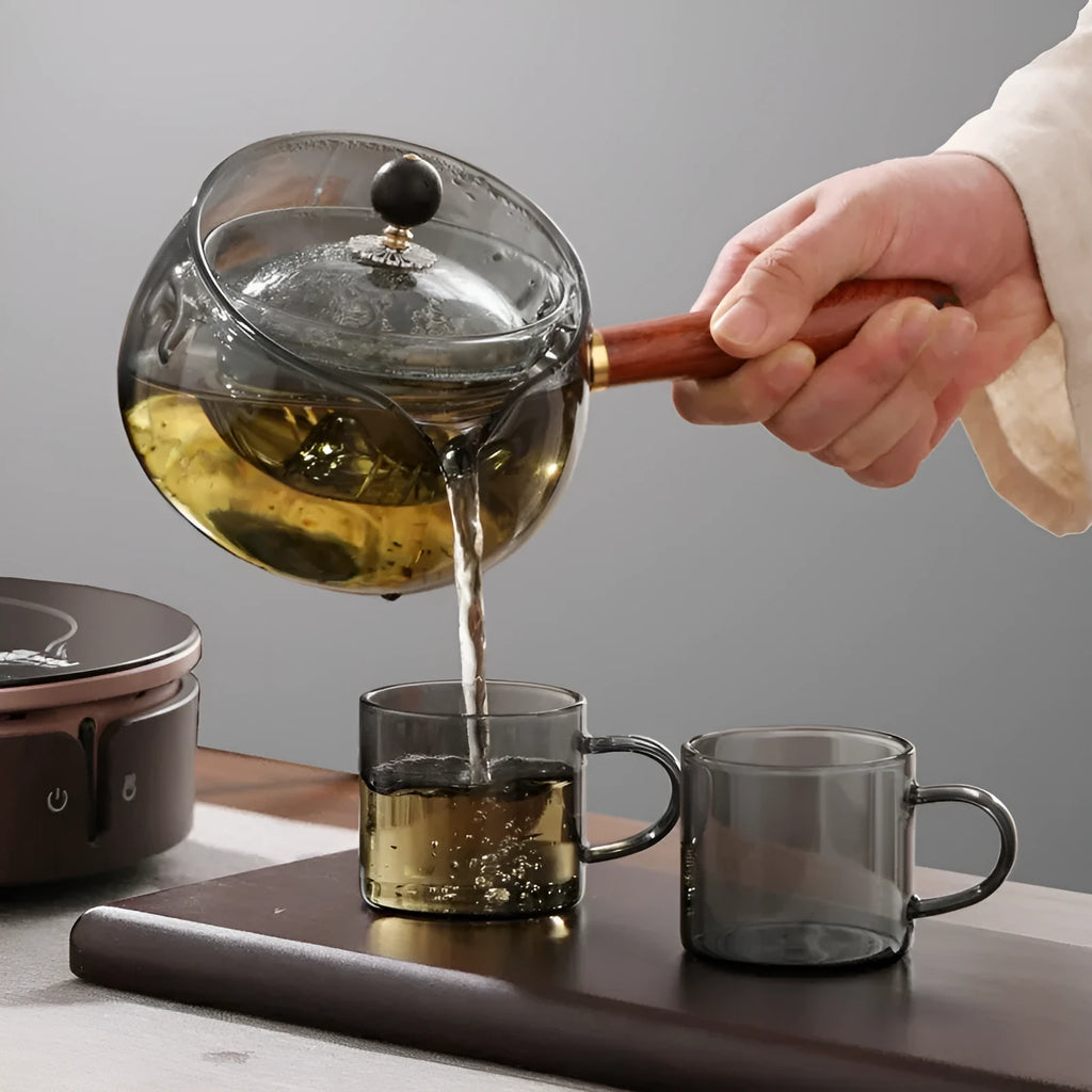 Transparent borosilicate glass teapot with wooden handle and infuser on rotary base