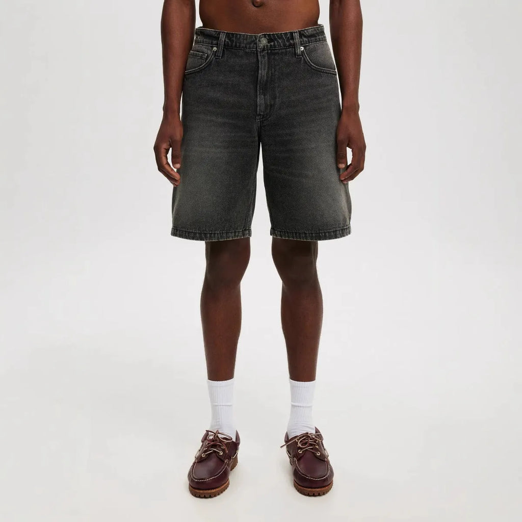 Men's loose straight-leg cotton jeans in light blue, black, and grey colours on a plain background.