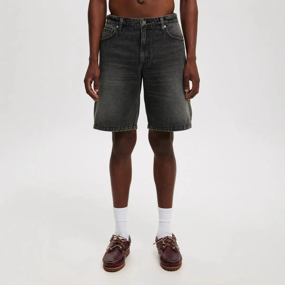 Men's loose straight-leg cotton jeans in light blue, black, and grey colours on a plain background.
