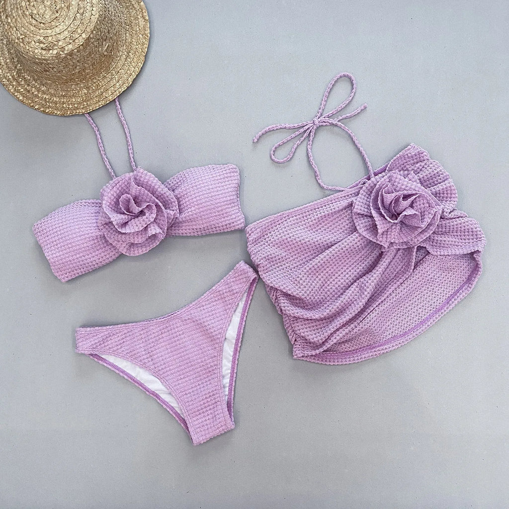 Women's white and purple three-piece bikini with 3D flower split design, includes bra, skirt, and briefs.