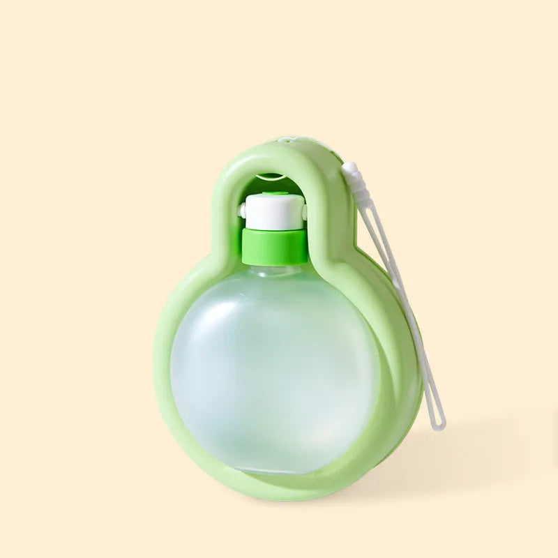 Green portable dog water bottle with pull-out drinking bowl on a table