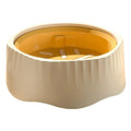 Blue plastic slow feeder dog bowl with detachable maze interior on a wooden floor.