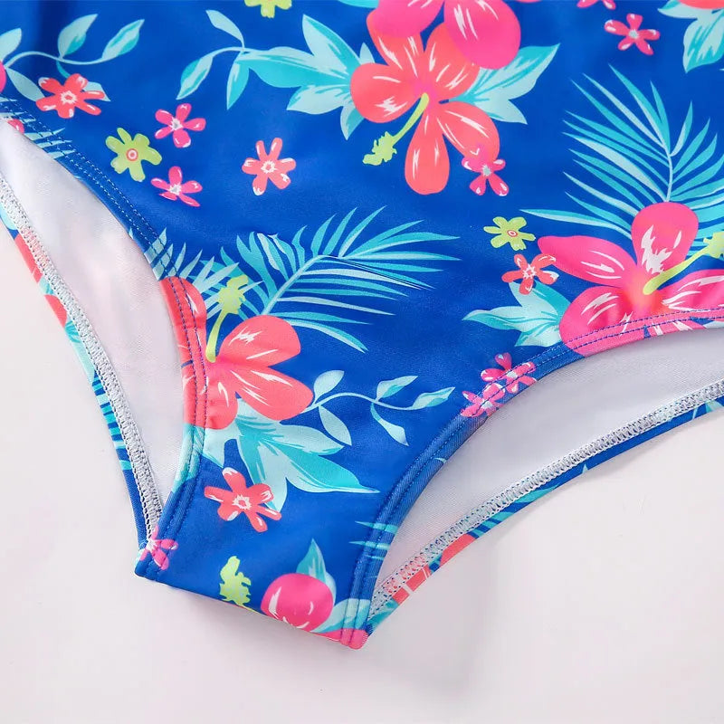 Girl's long-sleeve one-piece swimming suit in a bright colour, showing the full briefs-style design.
