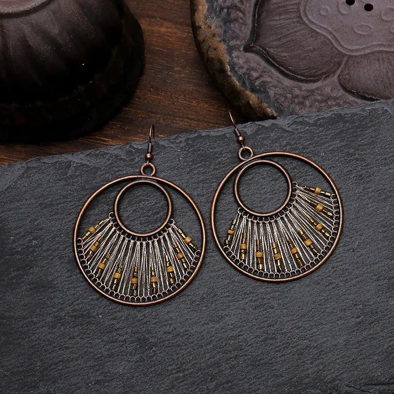 Bohemian hand-woven gold thread alloy earrings with geometric quadrilateral shape on a white background