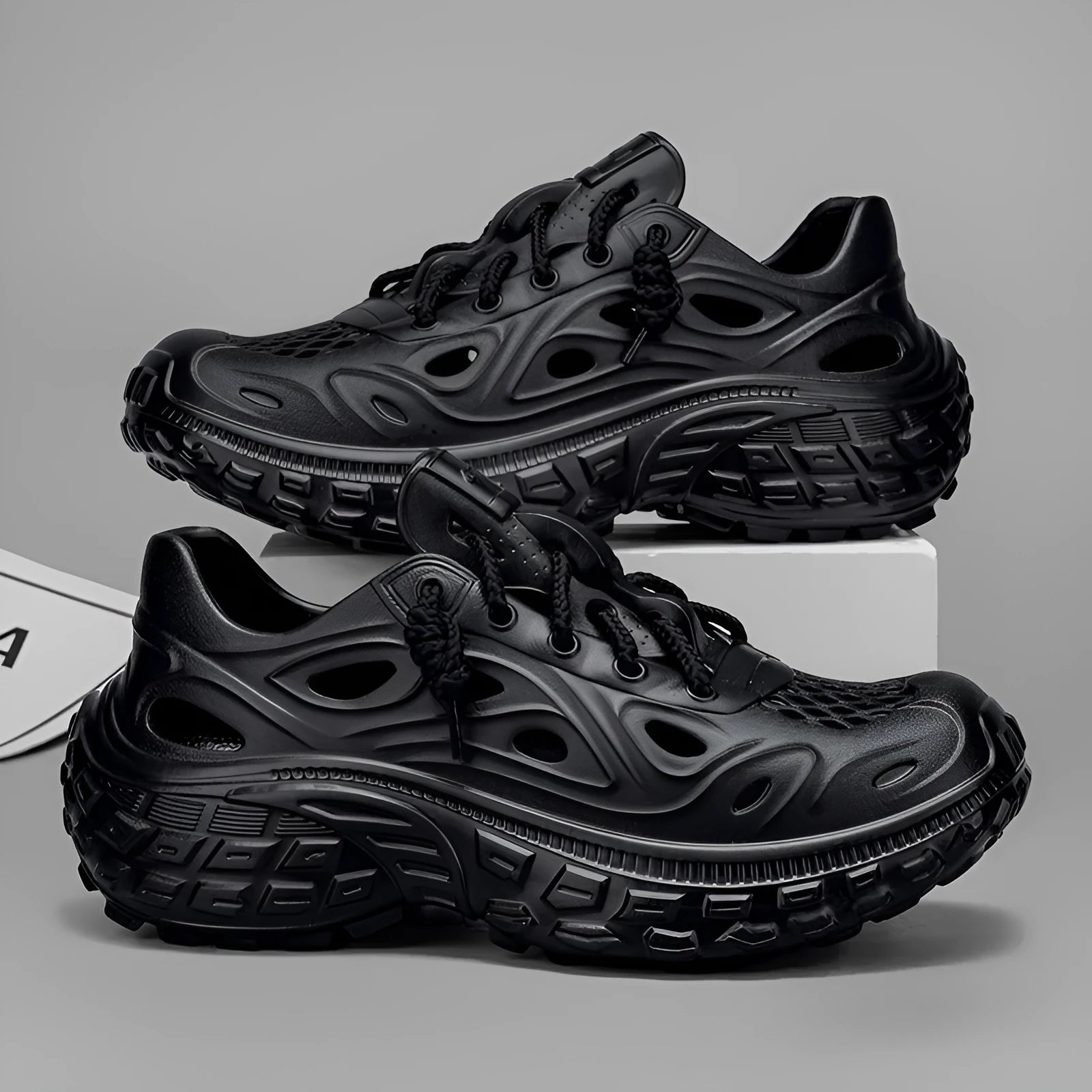 Men's black EVA sandals with a hollow out design and thick sole, shown on a foot.