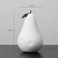 White and black resin apple and pear decorations showing high and low profile models on a wooden surface