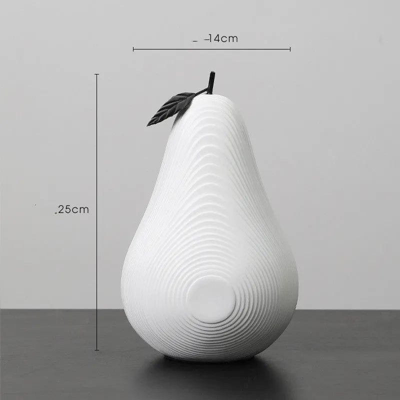 White and black resin apple and pear decorations showing high and low profile models on a wooden surface
