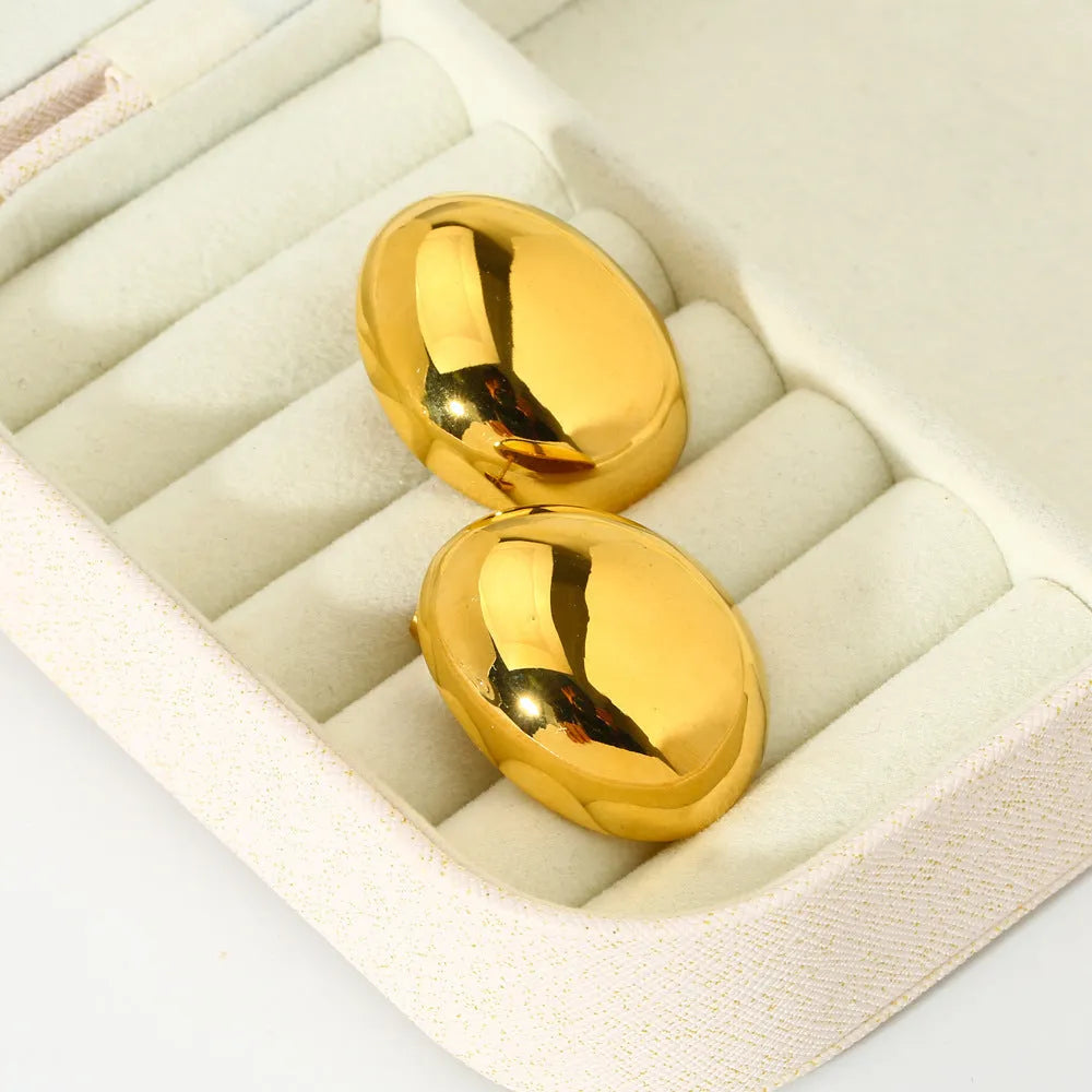Geometric stainless steel ear studs with a gold electroplated finish and exaggerated glazed surface.