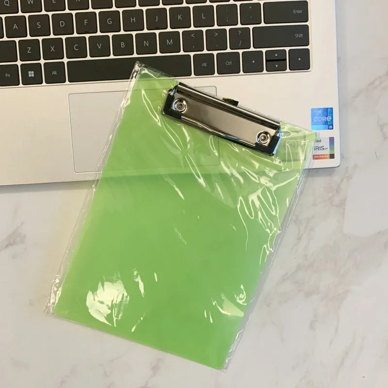 Transparent A4 clipboard with metal clip, shown in blue colour on a wooden desk.
