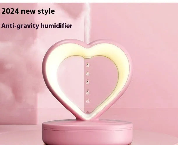 Love Anti Gravity humidifier, heart shaped with water droplet backflow, white colour, with ambience light, on a wooden desk