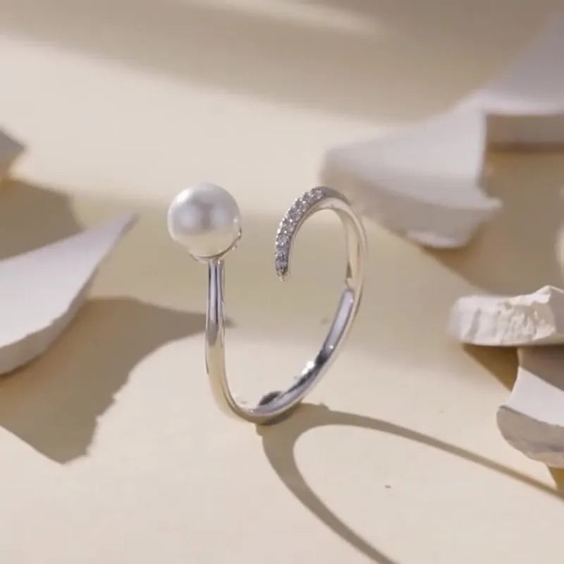 Women's S925 sterling silver adjustable ring with a natural pearl on an open loop.