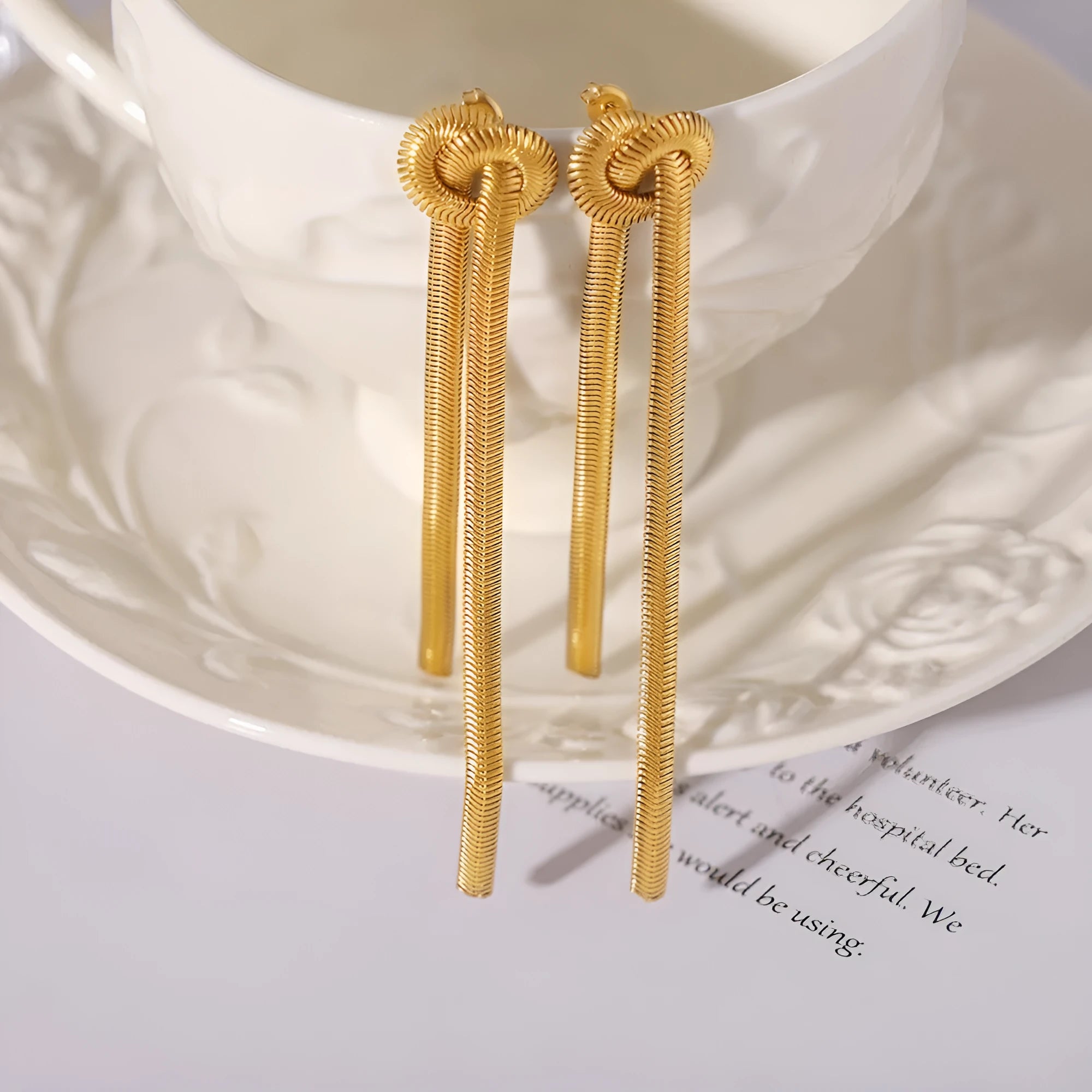 Gold knotted tassel snake chain long necklace with matching electroplated earrings on titanium steel