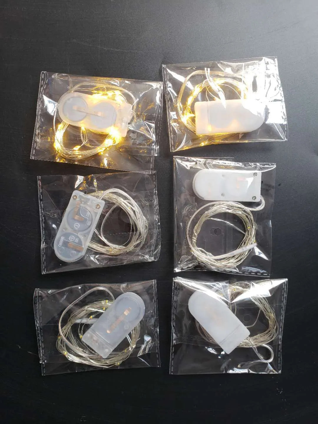 Close-up of a 2 metre long flexible copper wire LED light string with 20 small lights and a white plastic battery box.