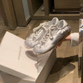 Women's silver satin ballet flats with round toe and white front lace-up on a rubber sole.
