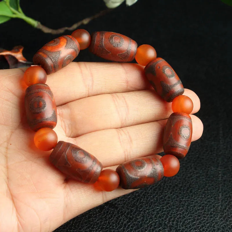 Distressed agate Tibet bead bracelet with three-eye design and polished finish on a wrist.