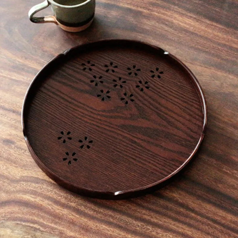 12 wooden circular plates with sakura flower cut-out designs arranged with storage tray