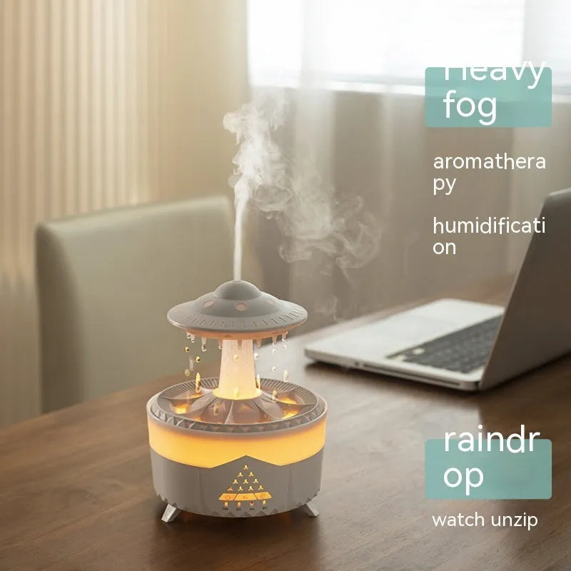 White cloud-shaped UFO raindrop humidifier diffuser with coloured night light on a wooden table.