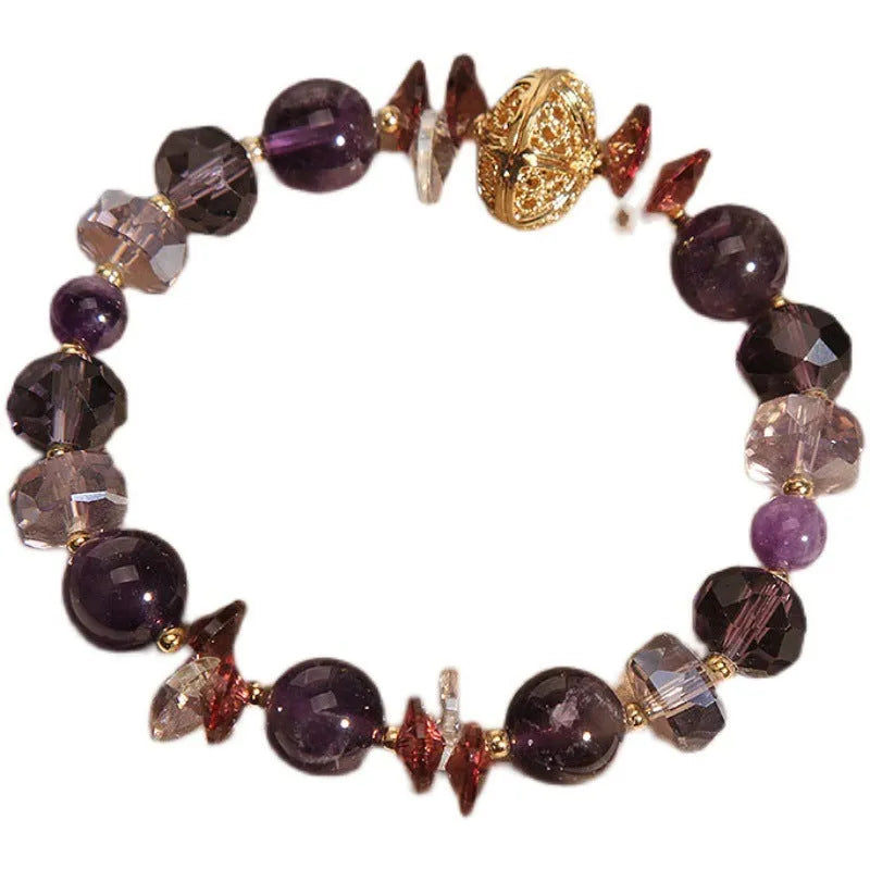Purple crystal bracelet with pumpkin beads, wind chime charms, and rhinestone details on wrist