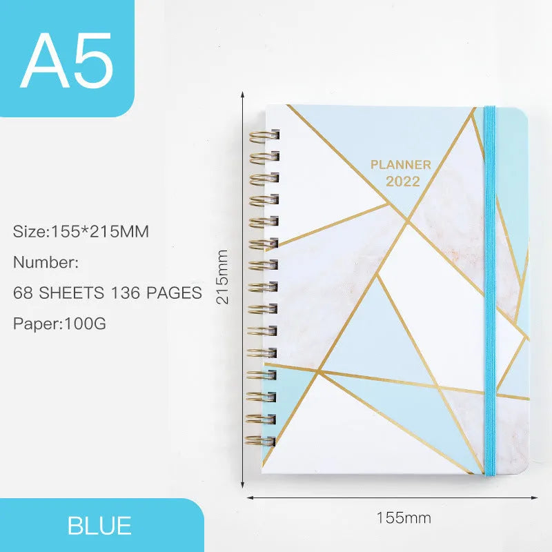 A5 spiral-bound notebook with a colourful floral design cover, lying open on a table.