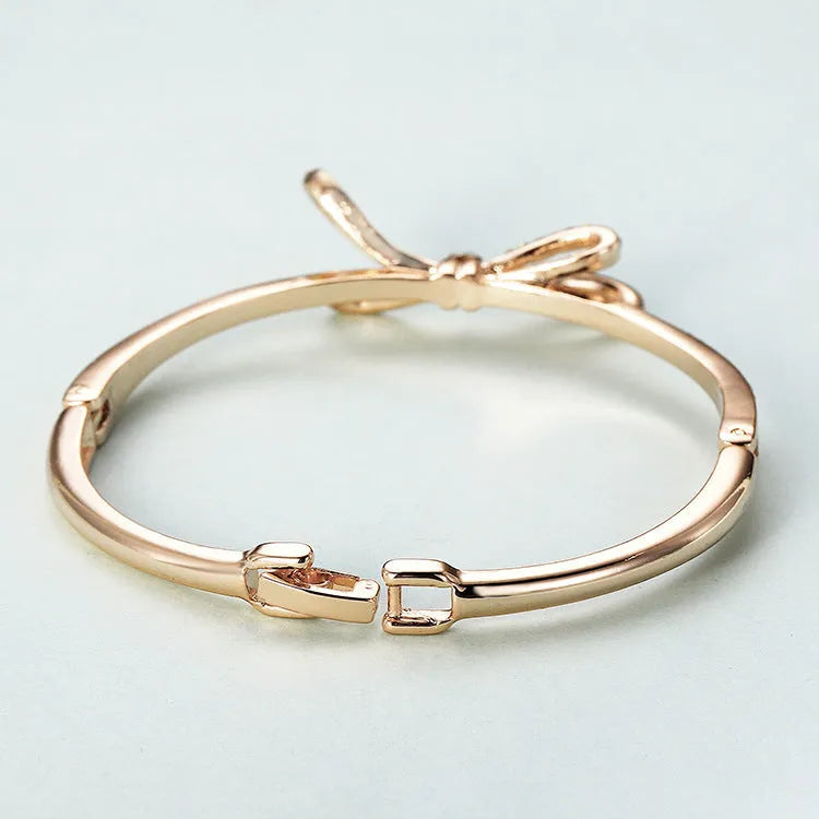Women's rose gold bow bracelet made from electroplated copper with a diamond feature