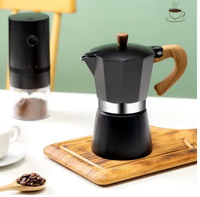 Italian mocha coffee pot in aluminium with long handle, black colour, standing on a stovetop