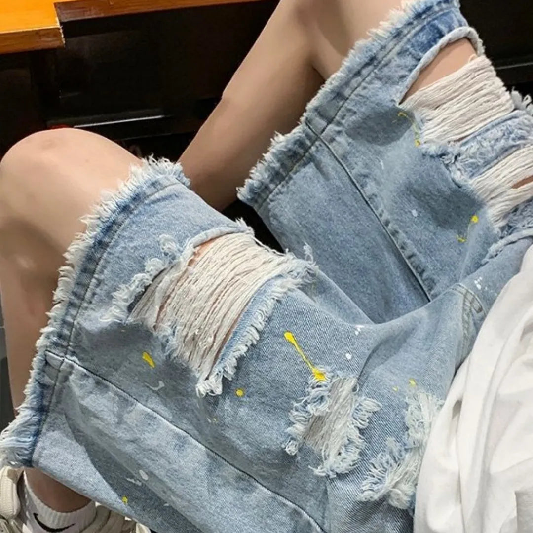 Man wearing loose-fit light blue water-washed denim shorts with hole details, for summer casual street style.