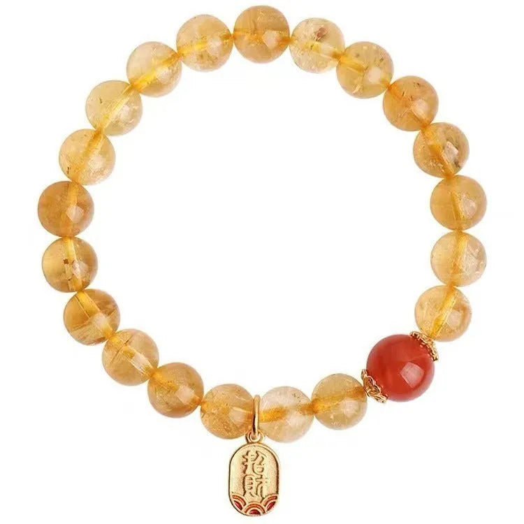 Red agate natural stone bracelet with gold and ruby accent beads on a wrist.